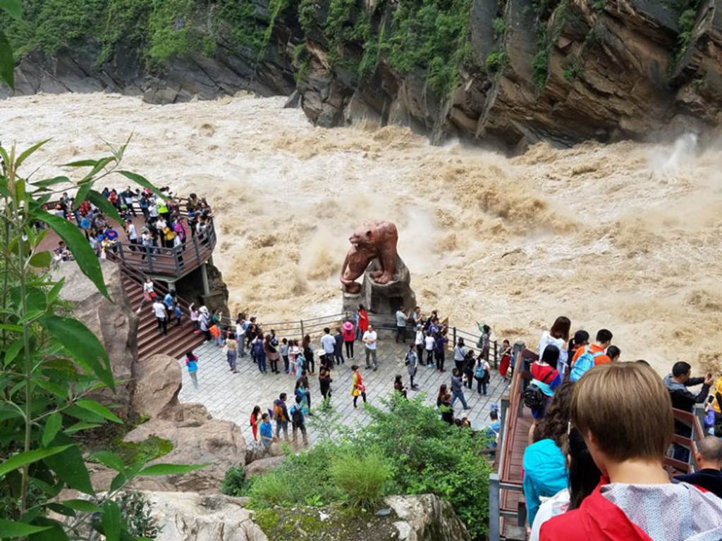 Tourists stand on a platform to view the rapids at Tiger Leaping Gorge along the Jinsha River in China